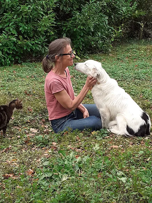 photo de l'artiste avec son border collie blanc et son chat tigré